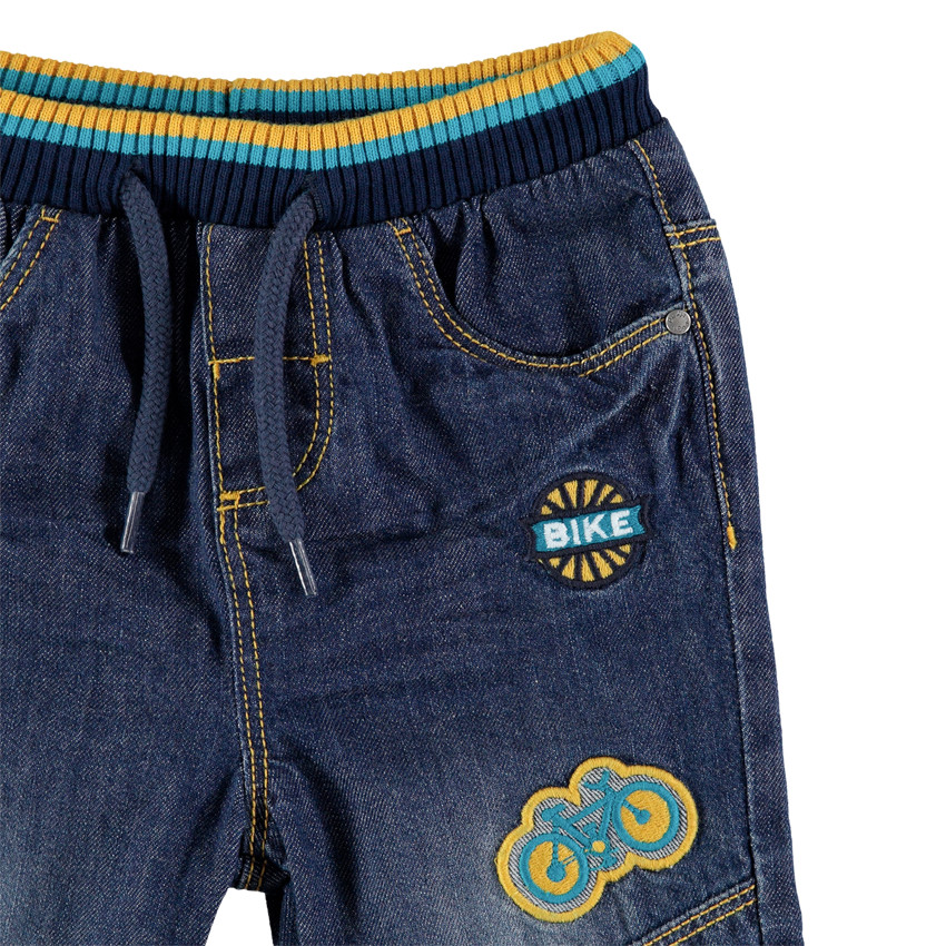 Τζιν με used όψη, λάστιχο στη μέση και απλικέ σήματα 